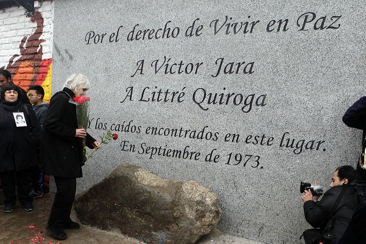 Joan Turner, bere senar Victor Jara zenaren memorialaren inaugurazio ekitaldian loreak jartzen, Santiagon. 2014ko irailean jarri zuten oroitarria, abeslariaren heriotzaren 40. urtemugan. SEBASTIAN SILVA / EFE.