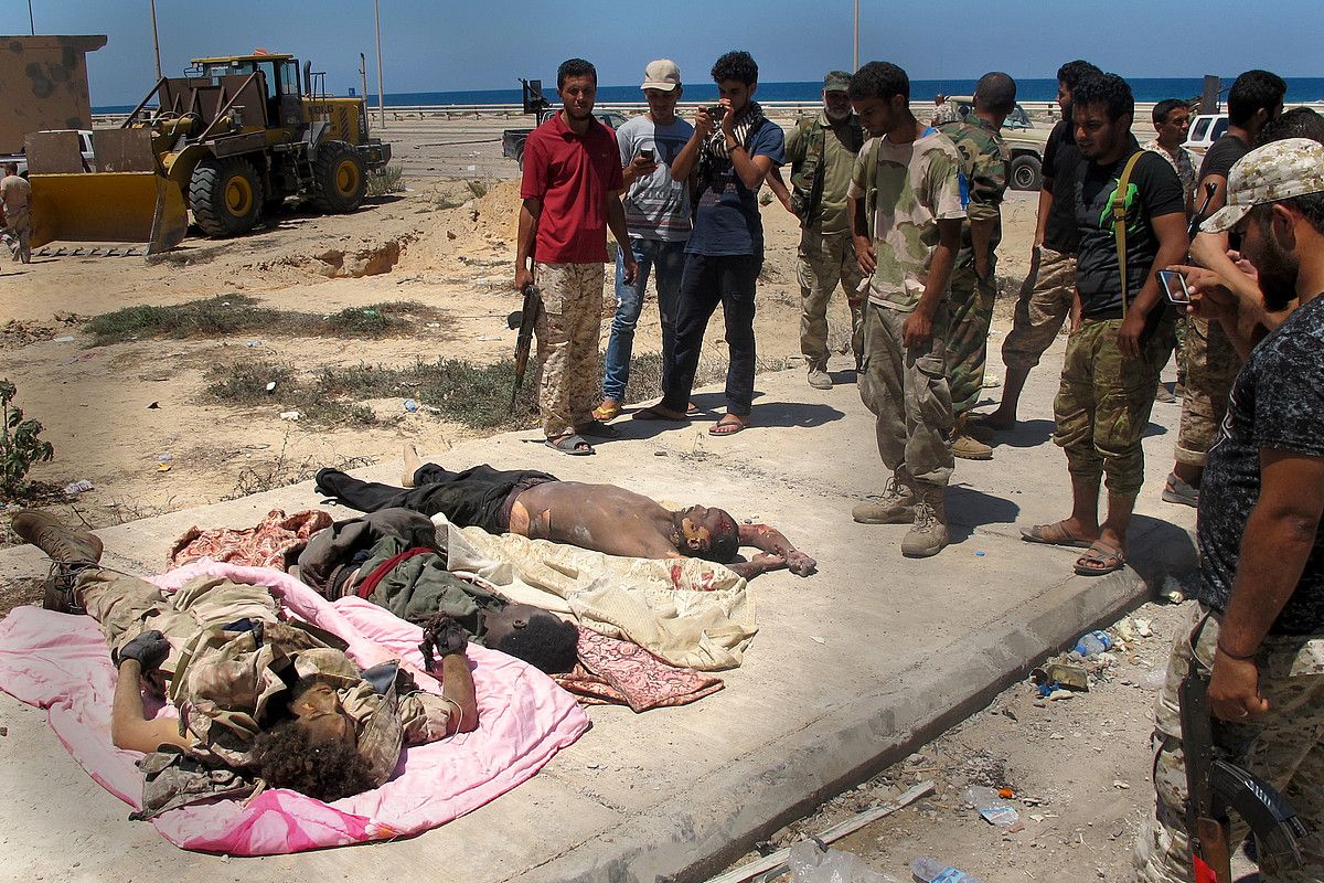 Libiako milizianoak, Estatu Islamikokohiru gerlariren gorpuen inguruan, Sirteko erdigunean. KARLOS ZURUTUZA.