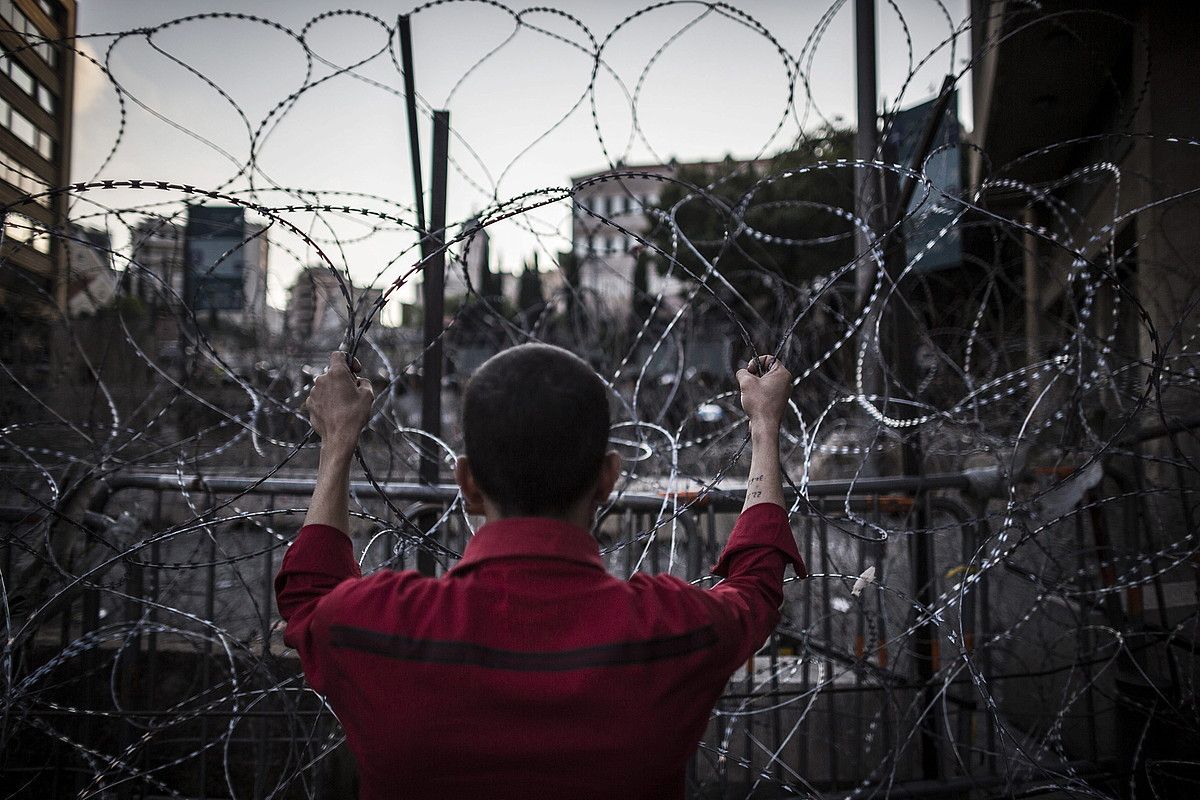 Herritar bat, Libanoko Gobernuaren egoitza inguratzen duen hesian, Beiruten. OLIVER WEIKEN / EFE. Herritar bat, Libanoko Gobernuaren egoitza inguratzen duen hesian, Beiruten. OLIVER WEIKEN / EFE.