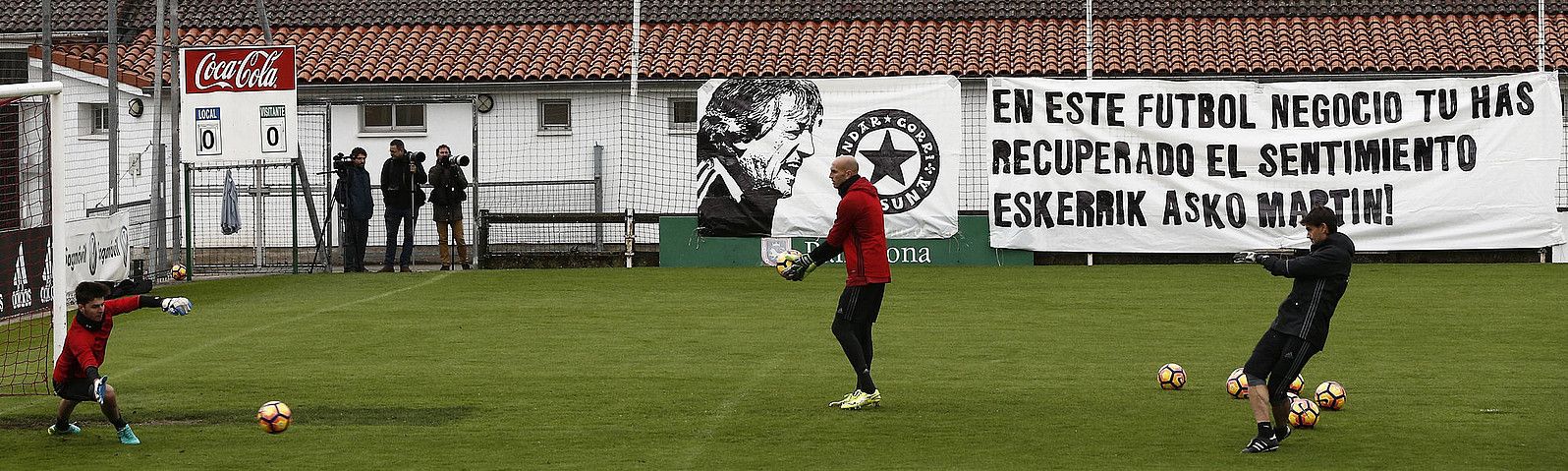 Osasunako atezainak, atzo, Taxoaren entrenatzen. Argazkian ikus daiteke Indar Gorri jarraitzaile taldeak Enrique Martinen alde jarritako pankarta. JESUS DIGES / EFE.