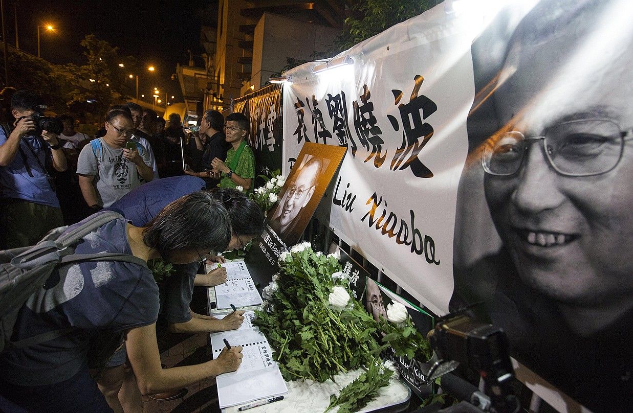 Herritarrak Liu Xiaoboren omenezko oharrak sinatzen, atzo, Hong Kongen. ALEX HOFFORD / EFE.