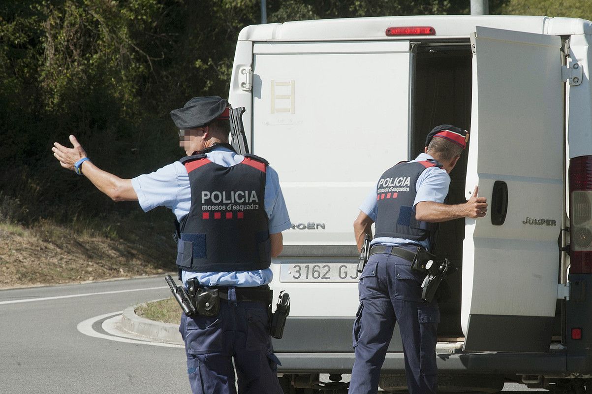 Mossos d'Esquadrako bi agente furgoneta bat miatzen, joan den astelehenean, Ripollen. ROBIN TOWNSEND / EFE.