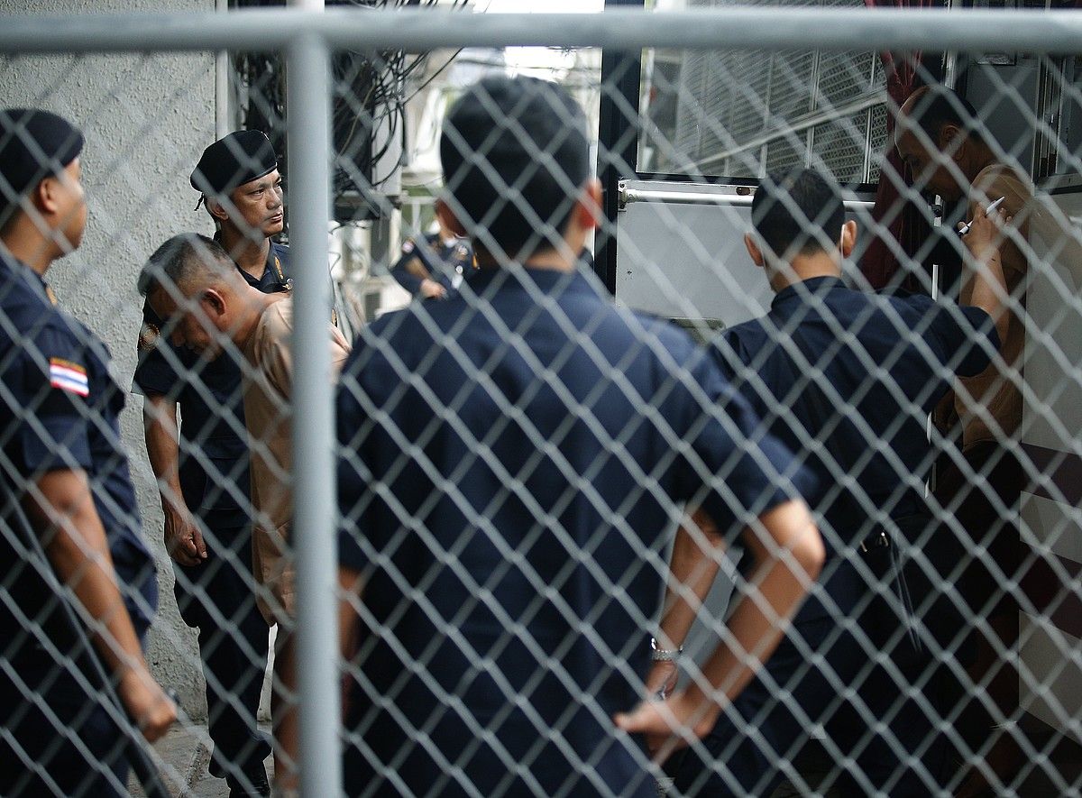 Thailandiako poliziak eta etorkin salerosle bat, Bangkokeko auzitegi bateko atarian. NARONG SANGNAK / EFE. Thailandiako poliziak eta etorkin salerosle bat, Bangkokeko auzitegi bateko atarian. NARONG SANGNAK / EFE.