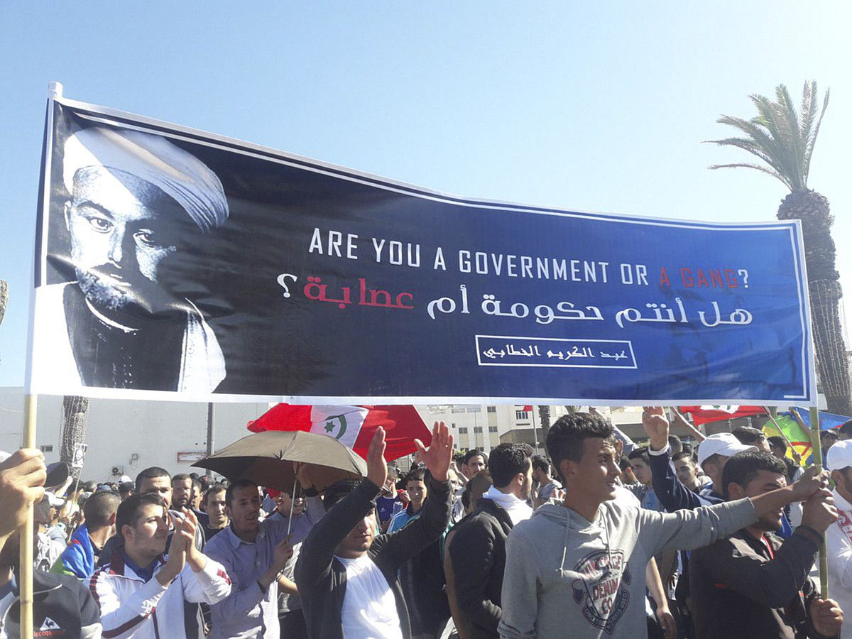 Al-Hoceiman maiatzean egin zen protestaren irudi bat. Abd el-Krim ageri da pankartan, galdetzen ea gobernu baten aurrean dauden edo talde kriminal baten aurrean. OMAR RADI. Al-Hoceiman maiatzean egin zen protestaren irudi bat. Abd el-Krim ageri da pankartan, galdetzen ea gobernu baten aurrean dauden edo talde kriminal baten aurrean. OMAR RADI.