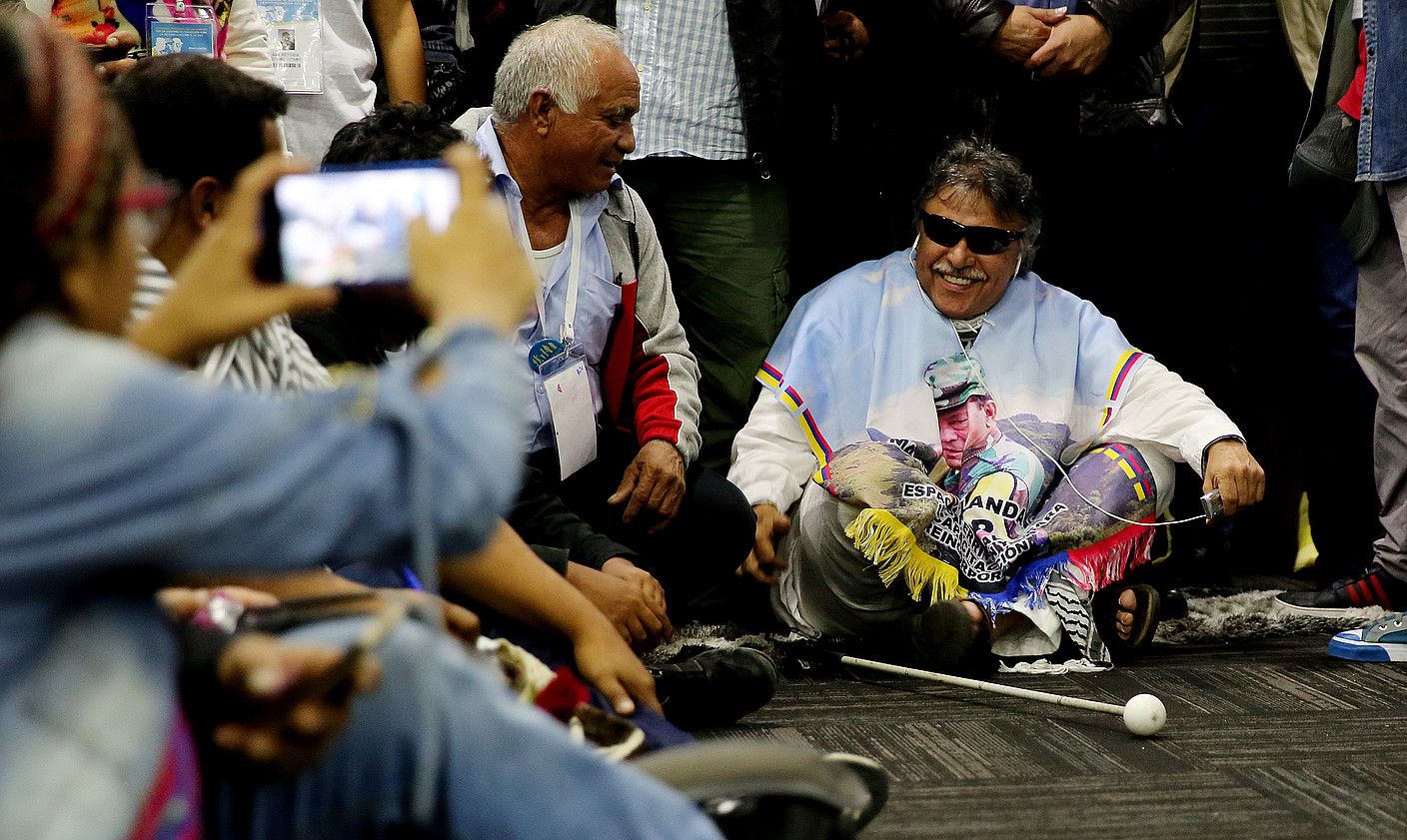 Jesus Santrich gerrillako kide historikoa lurrean eserita, atzo FARC alderdikoek egindako sorrera kongresuaren prentsaurrekoan. LEONARDO MUÑOZ / EFE. Jesus Santrich gerrillako kide historikoa lurrean eserita, atzo FARC alderdikoek egindako sorrera kongresuaren prentsaurrekoan. LEONARDO MUÑOZ / EFE.