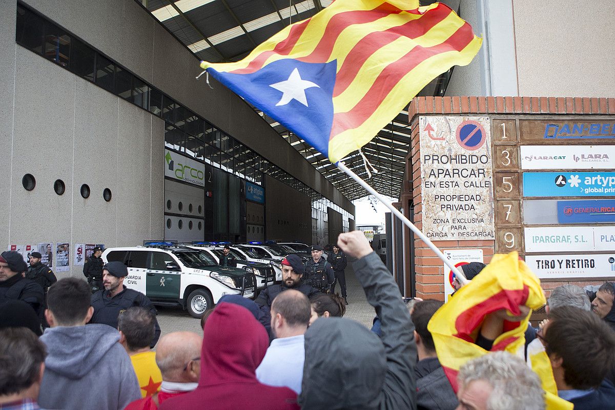 Jendea protesta egiten, atzo Guardia Zibilak Sant Feliu del Llobregaten miatu zuen inprentaren sarreran. QUIQUE GARCIA / EFE.