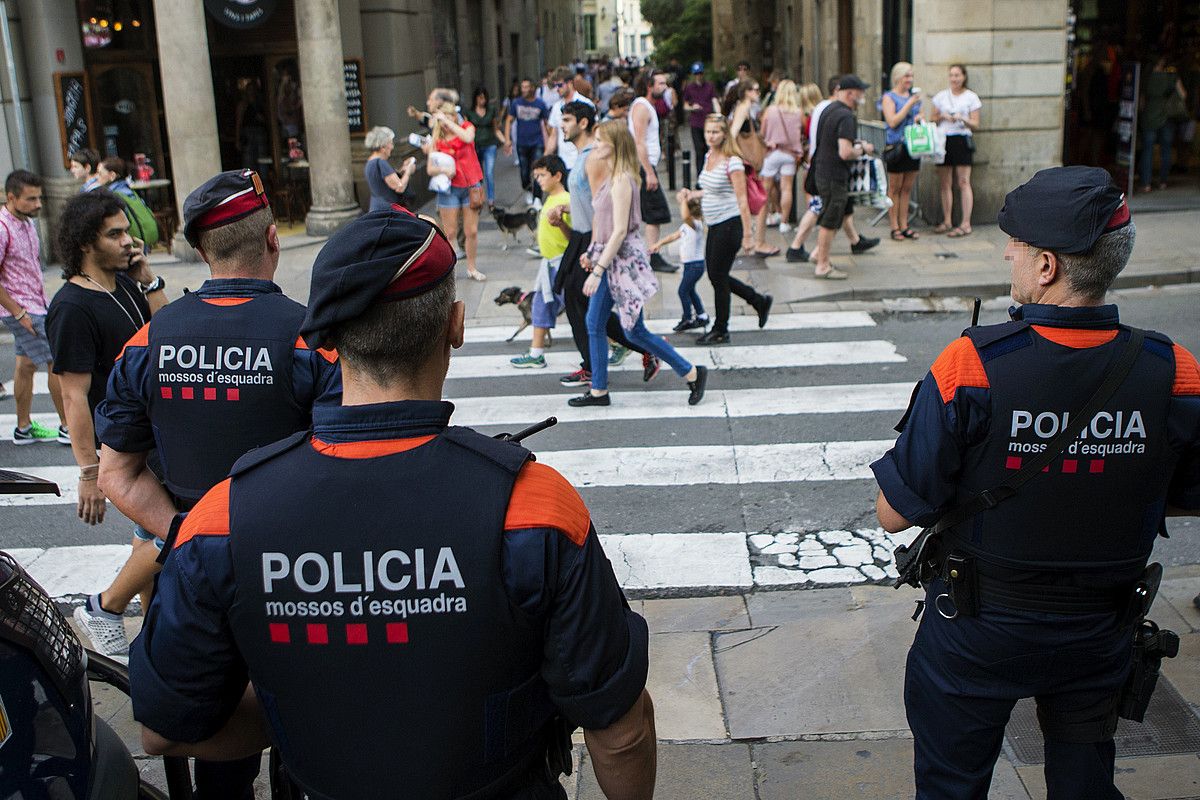 Mossos d'Esquadrako hiru agente zaintza lanetan, atzo, Bartzelonako erdigunean. QUIQUE GARCIA / EFE.