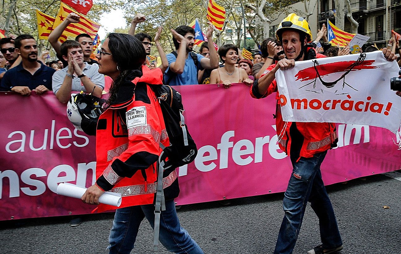 Suhiltzaileak ikasleekin bat egiten, atzoko Bartzelonako manifestazioan. JUAN CARLOS CARDENAS / EFE.