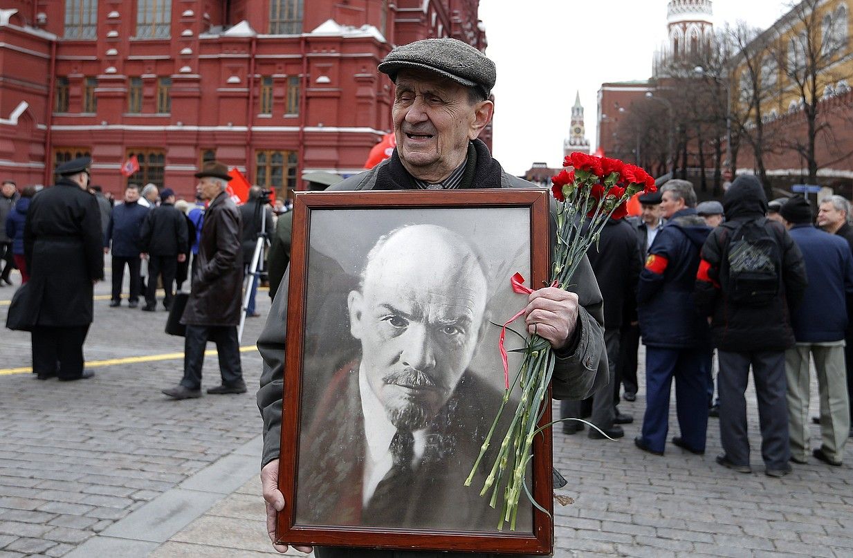 Pertsona bat Leninen potreta batekin, mausoleora sartzeko zain dagoen bitartean, aurten Moskun. MAXIM SHIPENKOV / EFE.