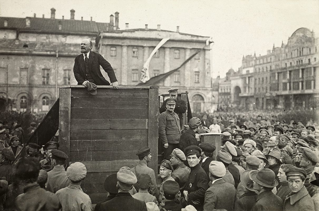 Vladimir Lenin boltxebikeen liderra hitzaldi bat ematen, 1920ko maiatzaren 5ean, Moskuko Sverdlov plazan. Oholtzaren eskuinean, kamerari begira, Leon Trotski ageri da. UKJENT. Vladimir Lenin boltxebikeen liderra hitzaldi bat ematen, 1920ko maiatzaren 5ean, Moskuko Sverdlov plazan. Oholtzaren eskuinean, kamerari begira, Leon Trotski ageri da. UKJENT.