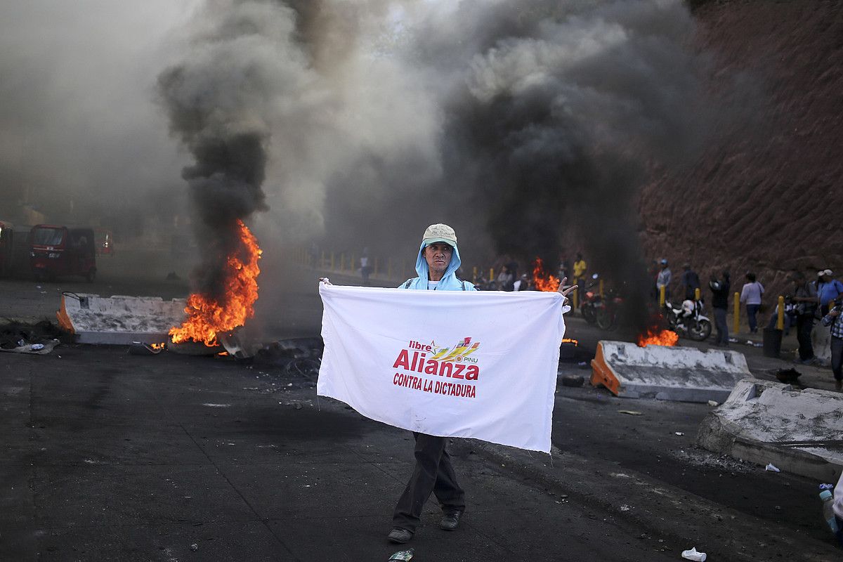 Oposizioaren jarraitzaileak kalean, protestan, herenegun, Tegucigalpan. GUSTAVO AMADOR / EFE.