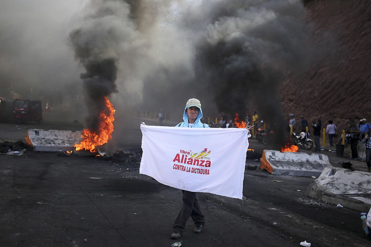 Oposizioaren jarraitzaileak kalean, protestan, herenegun, Tegucigalpan. GUSTAVO AMADOR / EFE. Oposizioaren jarraitzaileak kalean, protestan, herenegun, Tegucigalpan. GUSTAVO AMADOR / EFE.