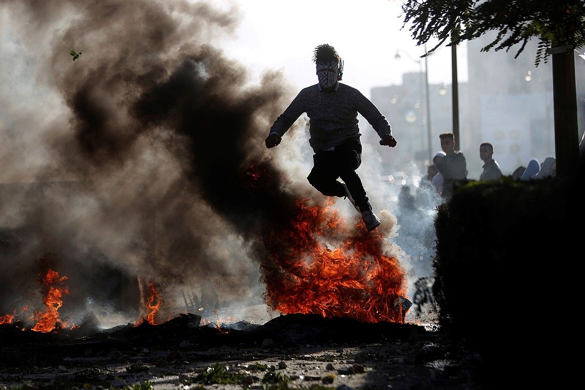 Manifestari bat sutan dauden pneumatikoen gainetik jauzi egiten, Ramallahen. Hiri horretan, soldaduek lau lagun zauritu zituzten tiroz. SHADI HATEM / EFE.