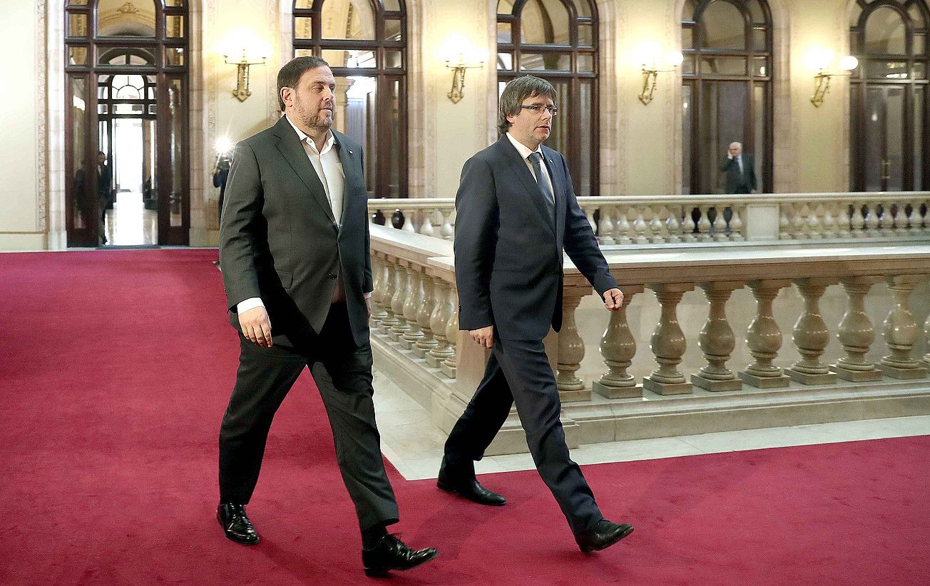 Oriol Junqueras eta Carles Puigdemont, iazko abenduan, Kataluniako Parlamentuan. Preso dago egun ERCko burua, eta erbestean JPCko zerrendaburua. ANDREU DALMAU / EFE.