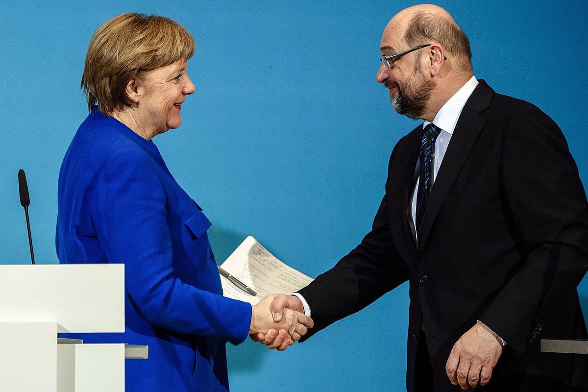 Angela Merkel eta Matin Schulz elkarri eskua ematen, atzo, Berlinen. CLEMENS BILAN / EFE.