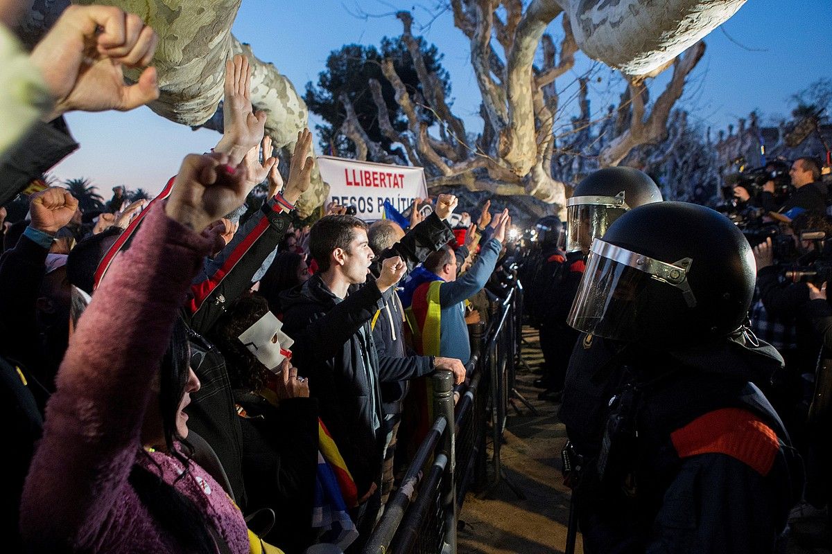 Herritarrak, mossoekin parez pare, atzo, parlamentuaren aurrean, Bartzelonan. QUIQUE GARCIA / EFE.