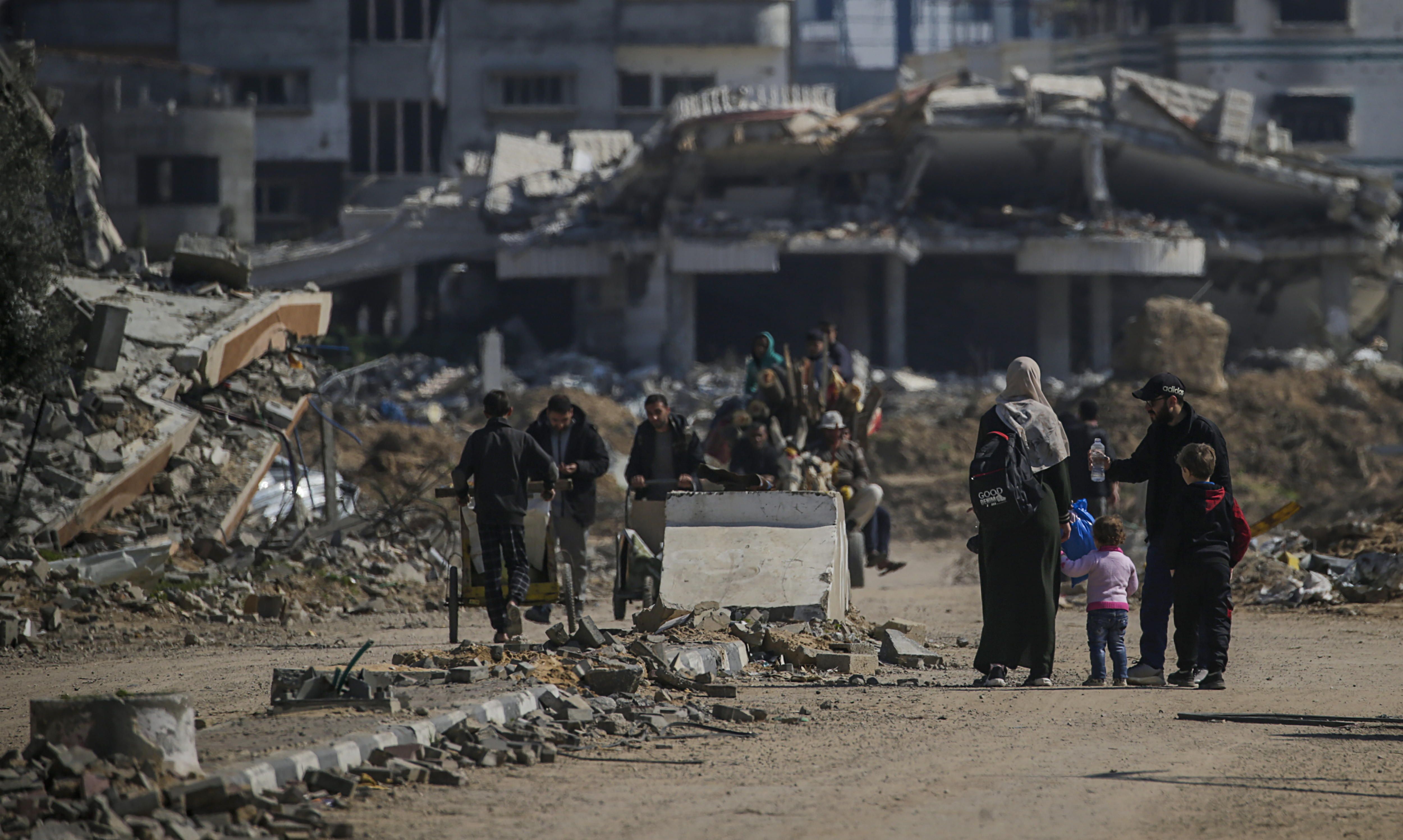 Palestinar batzuk Al-Nusairateko errefuxiatu esparrutik gertu eraitsitako eraikinetan, herenegun. MOHAMMED SABER / EFE