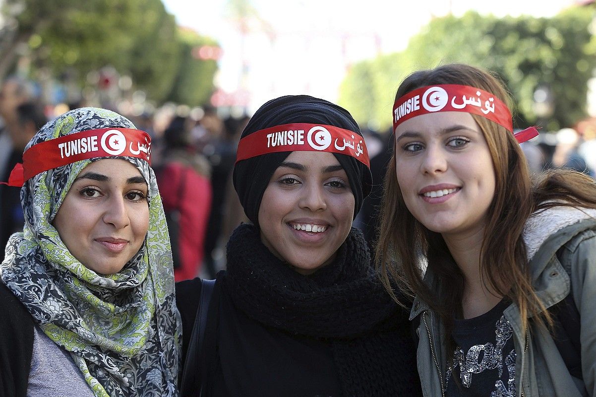 Tunisiako hiru neska gazte, Ben Aliren diktaduraren amaieraren bosgarren urteurreneko ospakizunean, Tunisen, duela bi urte. MOHAMED MESSARA / EFE. Tunisiako hiru neska gazte, Ben Aliren diktaduraren amaieraren bosgarren urteurreneko ospakizunean, Tunisen, duela bi urte. MOHAMED MESSARA / EFE.