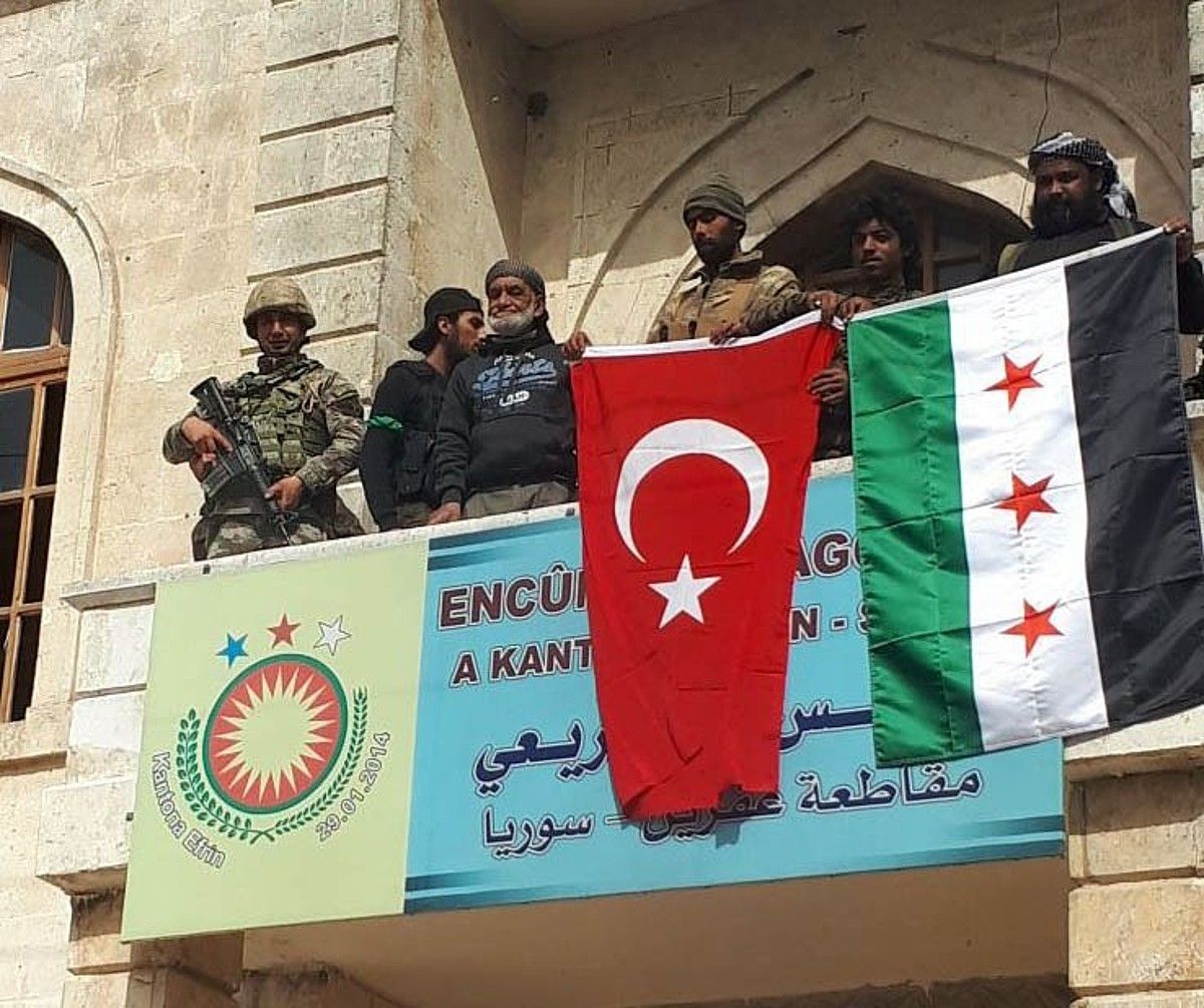 Inbaditzaileak Afringo barrutiaren legebiltzarrean, herenegun, Turkiako eta Siriako oposizioaren banderekin. EFE.