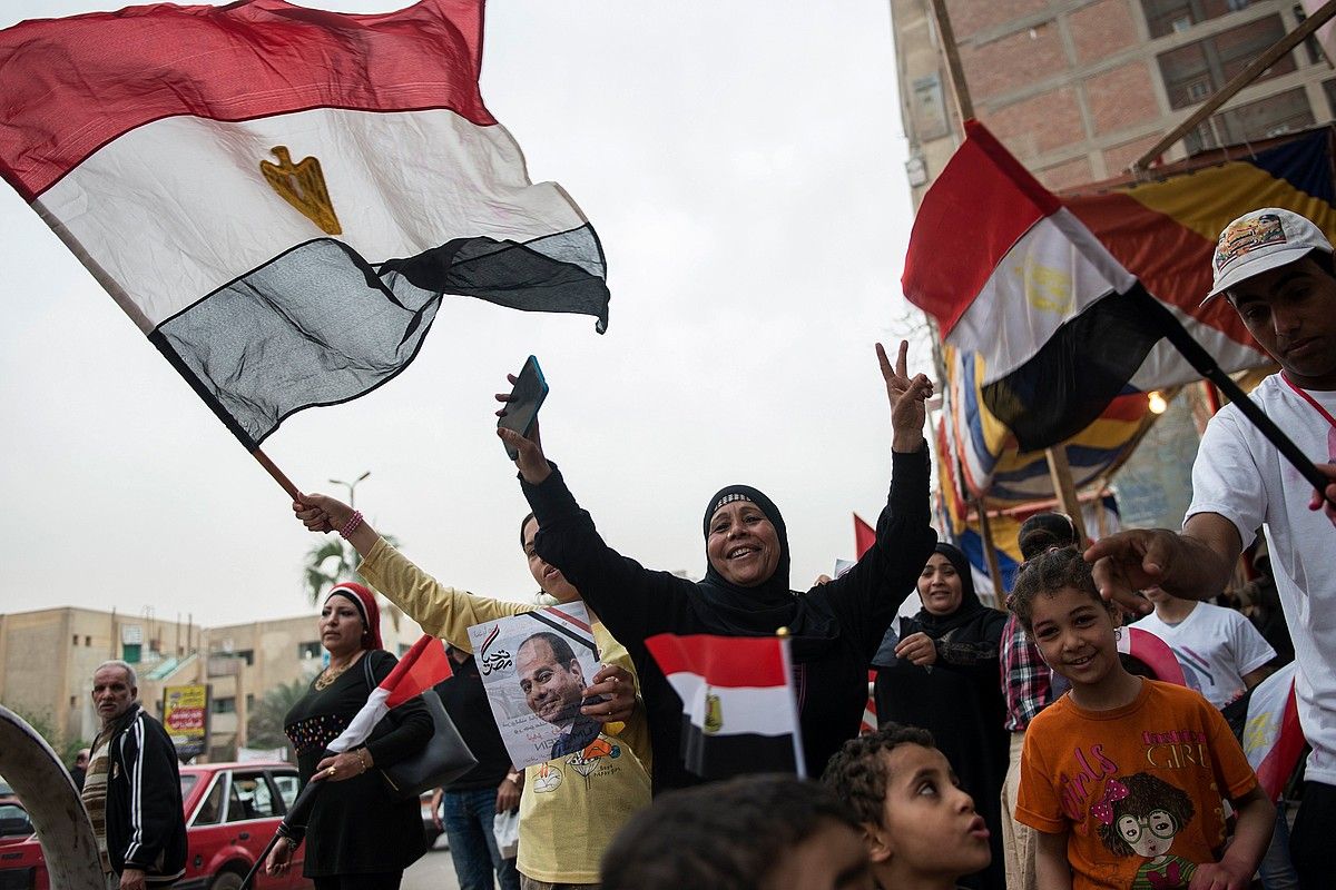 Al-Sisi presidentearen jarraitzaileak, atzo, Kairoko hautesleku baten ondoan. MOHAMED HOSSAM / EFE.