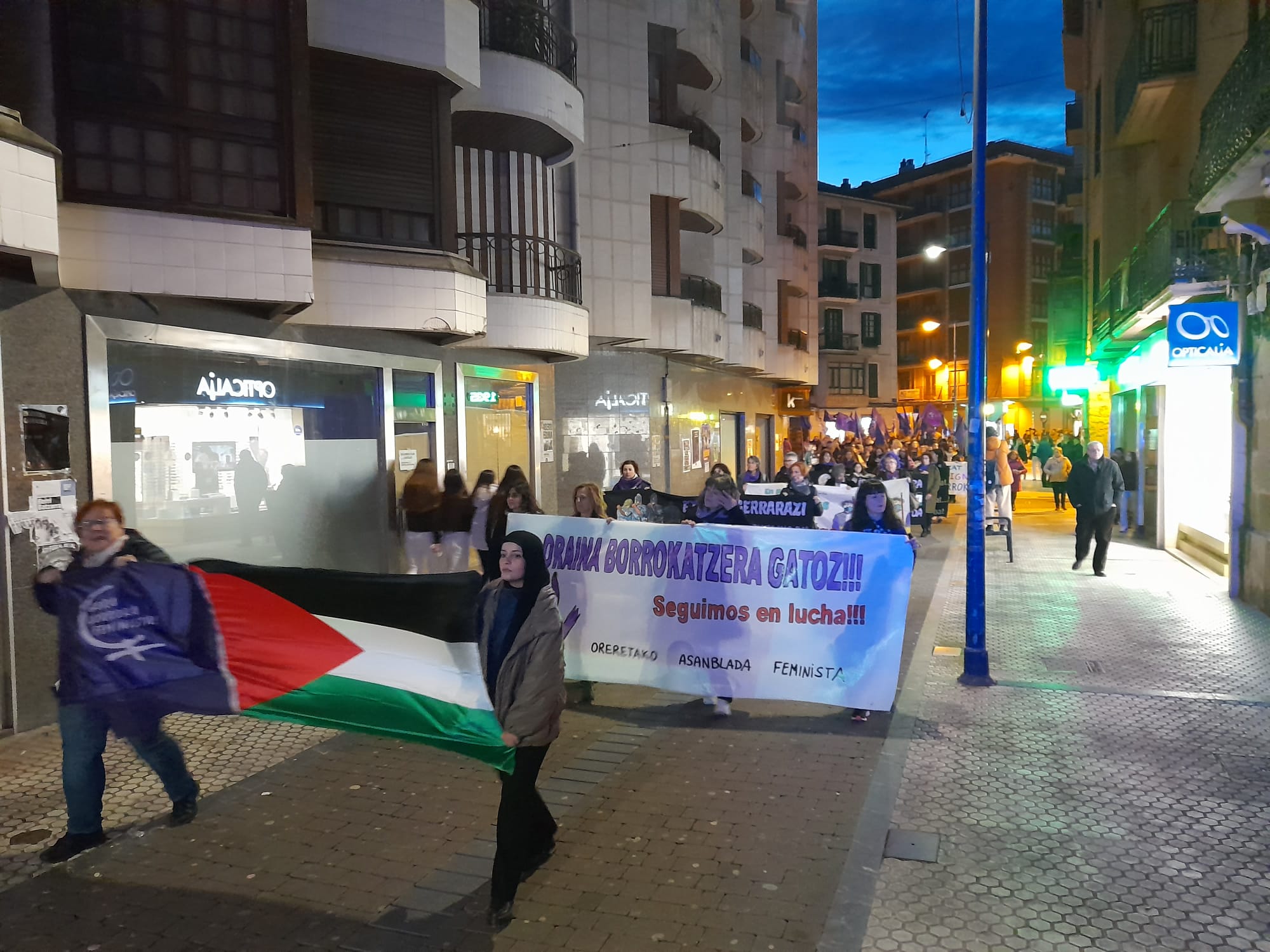 Oreretako asanblada feministak 'Oraina borrokatzera gatoz' dioen pankarta atera du kalera. Haren aurretik, Palestinako bandera.