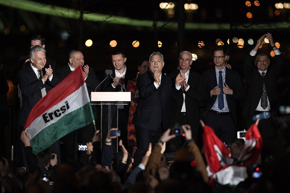Viktor Orban, erdian, igandeko hauteskundeetako garaipena ospatzeko ekitaldian. SZILARD KOSZTICSAK / EFE. Viktor Orban, erdian, igandeko hauteskundeetako garaipena ospatzeko ekitaldian. SZILARD KOSZTICSAK / EFE.