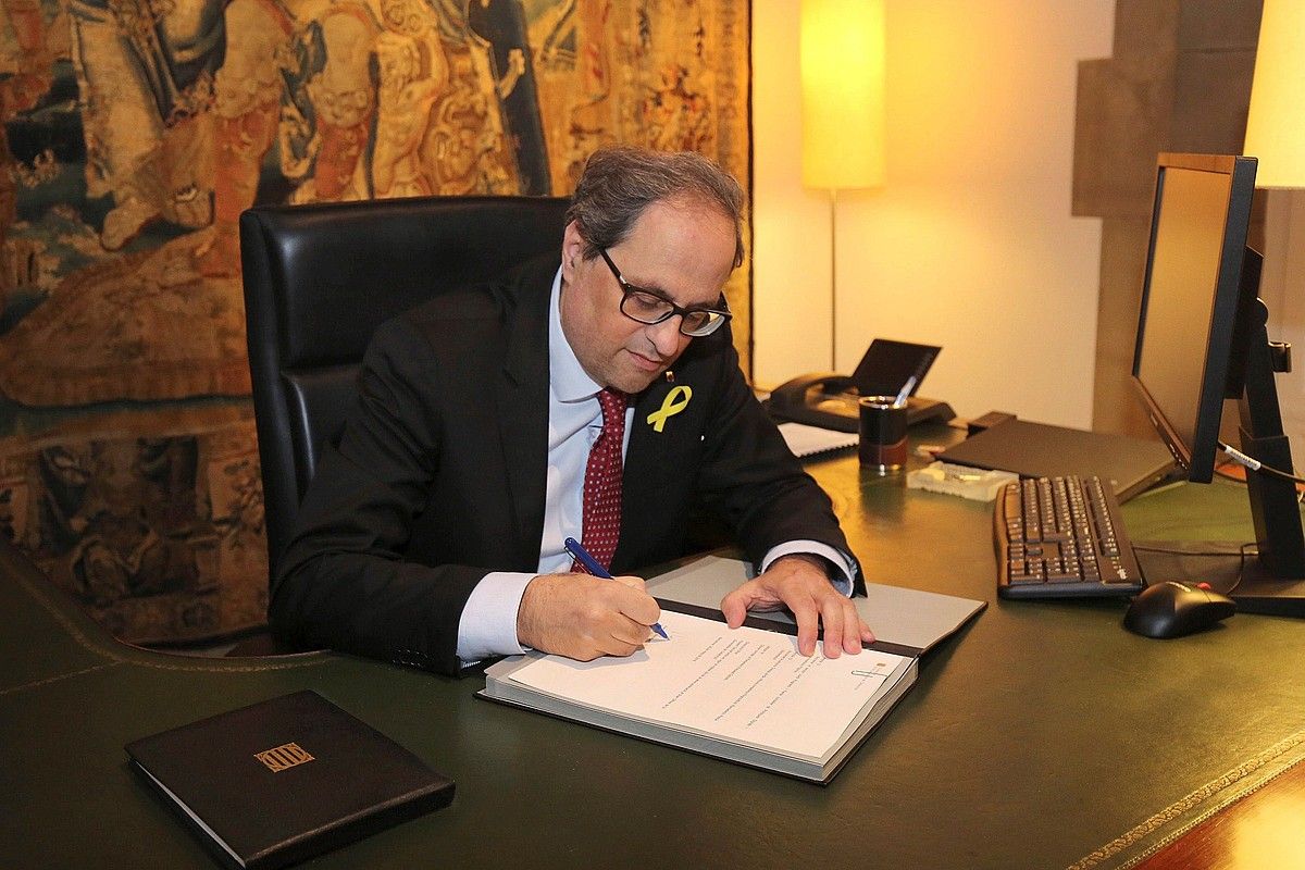 Quim Torra Kataluniako presidentea Generalitatearen egoitzan, atzo, gobernuko kideak izendatzeko dekretua sinatzen. JORDI BEDMAR PASCUAL / EFE.