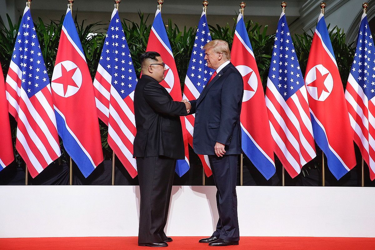 Kim Jong-un Ipar Koreako buruzagi gorena eta Donald Trump AEBetako presidentea elkarri bostekoa ematen, atzo, Sentosan, Singapurren. KEVIN LIM / EFE.