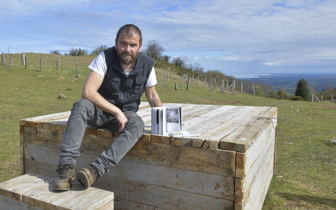 Asier Gogortza argazkilaria, hariztian, ‘Zaldaina’ eskulturan eserita. IDOIA ZABALETA / FOKU