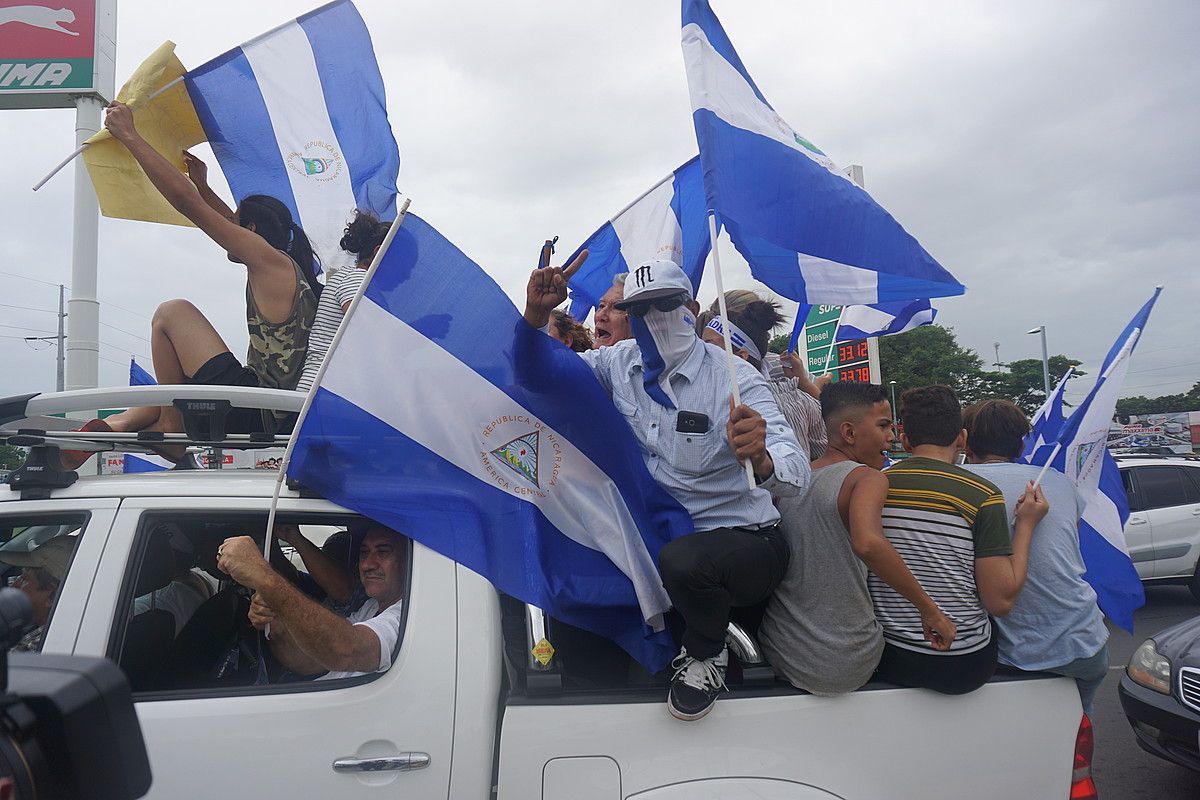 Hainbat lagun auto baten gainean asteon Managuan, Ortegaren aurkako manifestazio batean. JON ARTANO IZETA. Hainbat lagun auto baten gainean asteon Managuan, Ortegaren aurkako manifestazio batean. JON ARTANO IZETA.