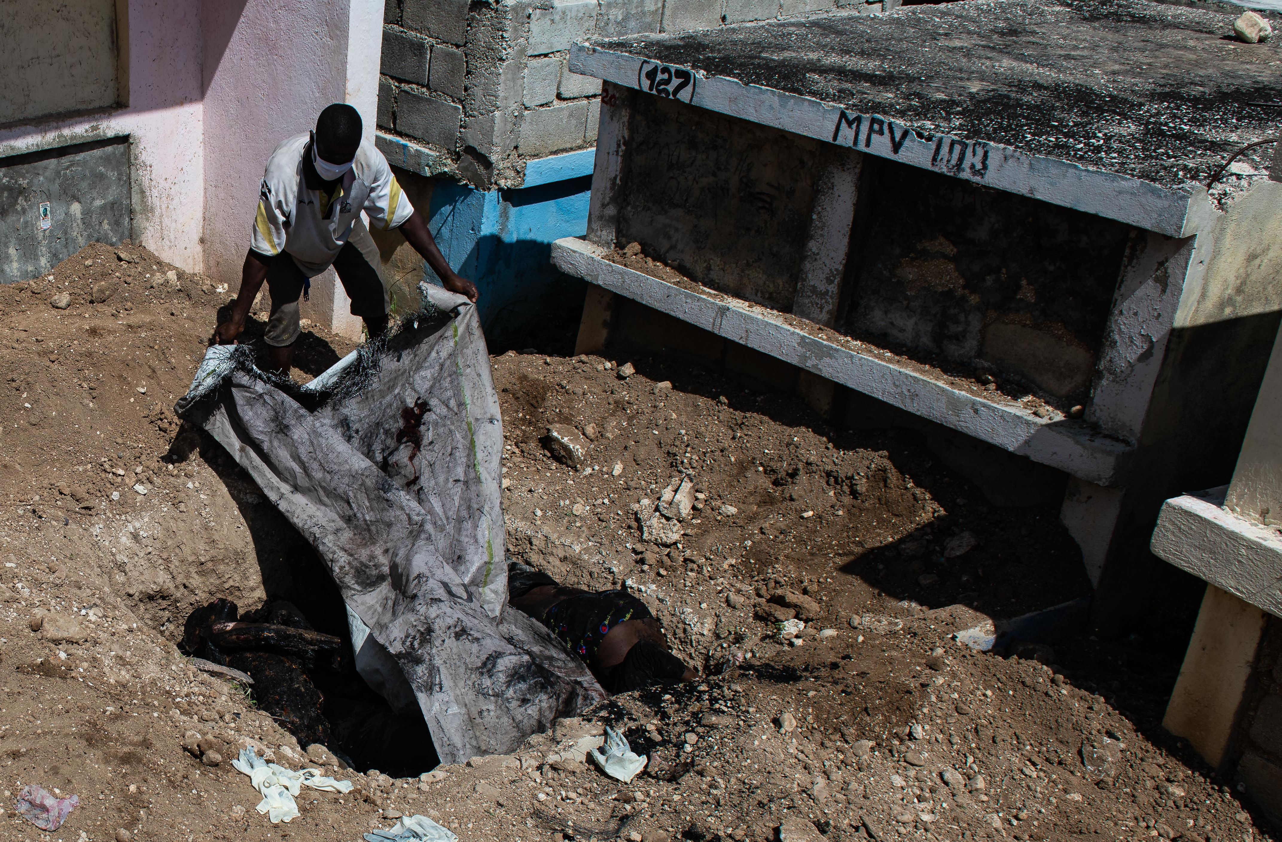 Martxoaren 12an, hainbat hildako lurperatzen, Port-au-Princeko hilerri batean egindako hobi batean. JOHNSON SABIN / EFE