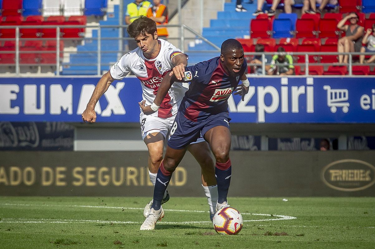 Pape Diop, Gonzalo Melero Huescako erdilariarekin lehian, ligako estreinakoan. JAIZKI FONTANEDA / FOKU.