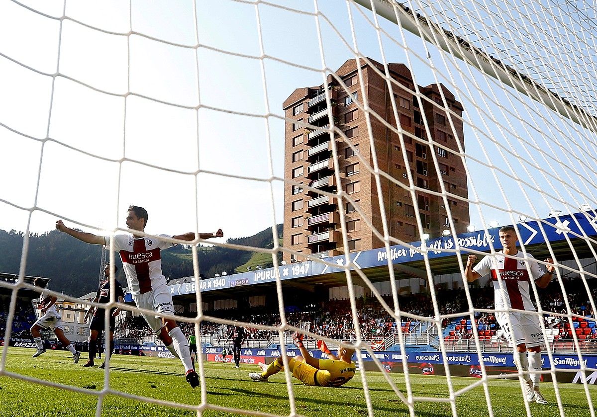 Huescako jokalariak gola ospatzen, Eibarreko atezain Dimitrovic lurrean dagoela. JAVIER ETXEZARRETA / EFE.