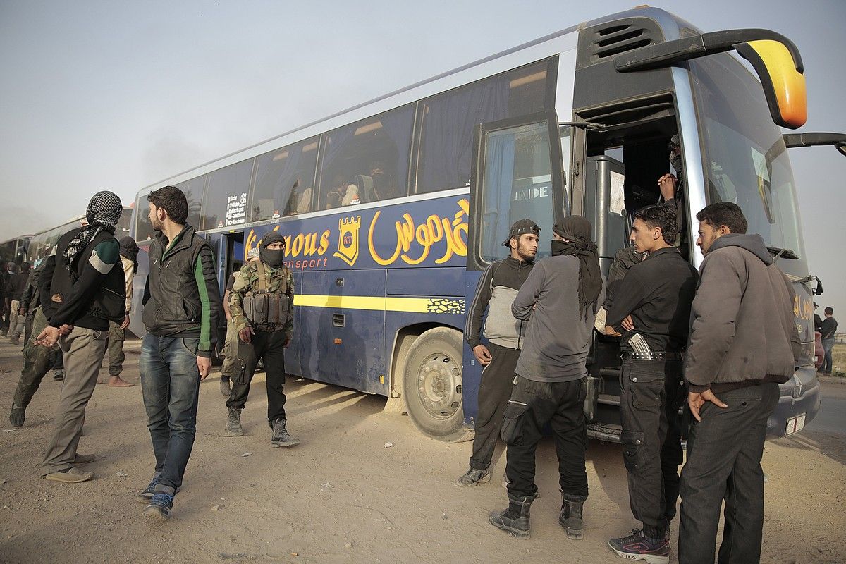 Matxino islamistak Damasko inguruan, iragan martxoan, gobernuaren autobusen alboan. Idlibera joan ziren. YOUSSEF BADAWI / EFE.