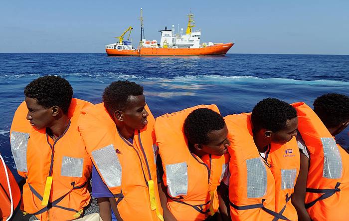 Migratzaile batzuk, abuztuan, 'Aquarius' ontziak (atzea) erreskatatu zain. GUGLIELMO MANGIAPANE, SOS MEDITERRANEE - EFE