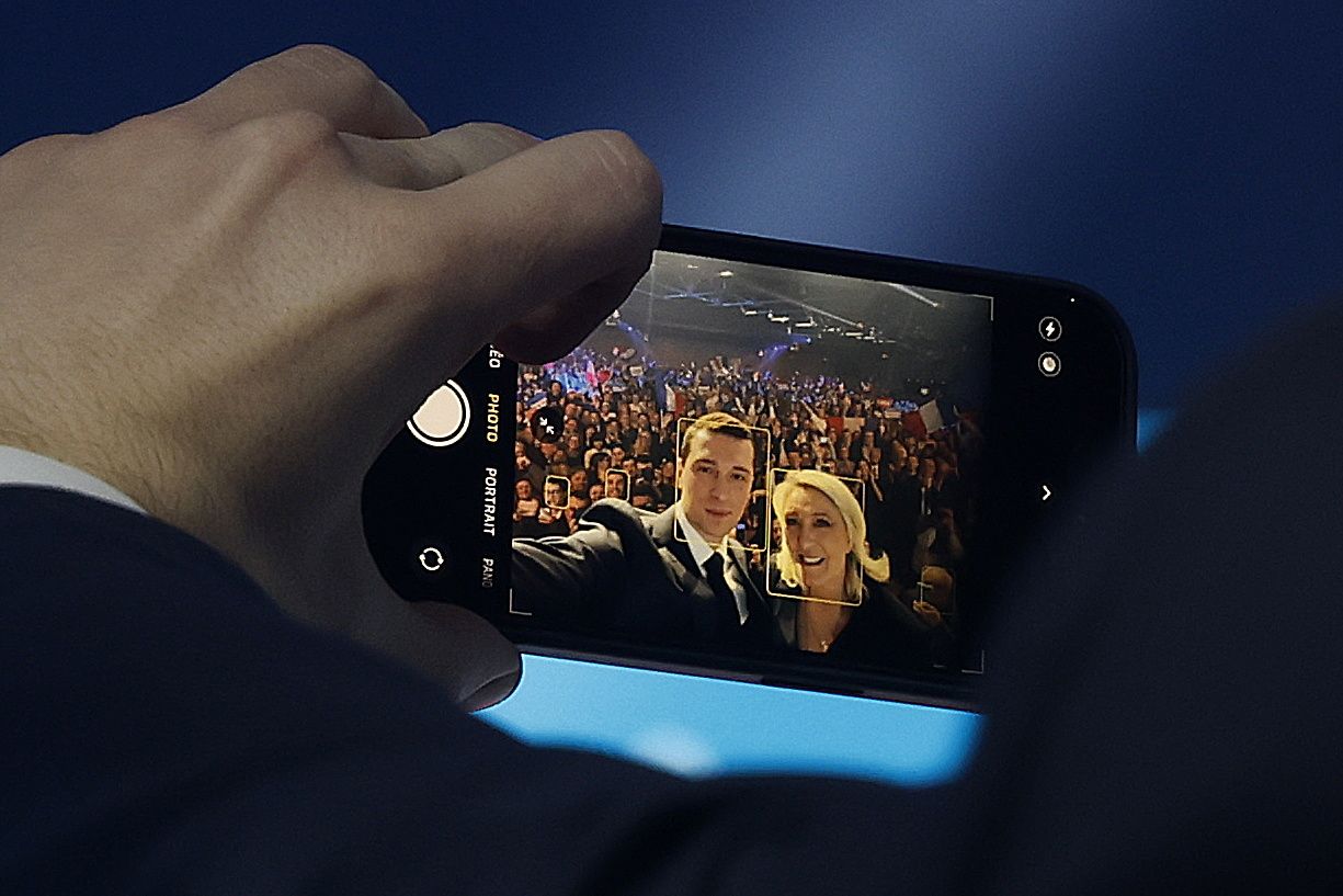 Ezkerretik eskuinera: Jordan Bardella RNren presidentea eta Marine Le Pen alderdiaren presidente izandakoa (2011-2021), iragan martxoan, mitin batean selfie bat egiten. GUILLAUME HORCAJUELO / EFE