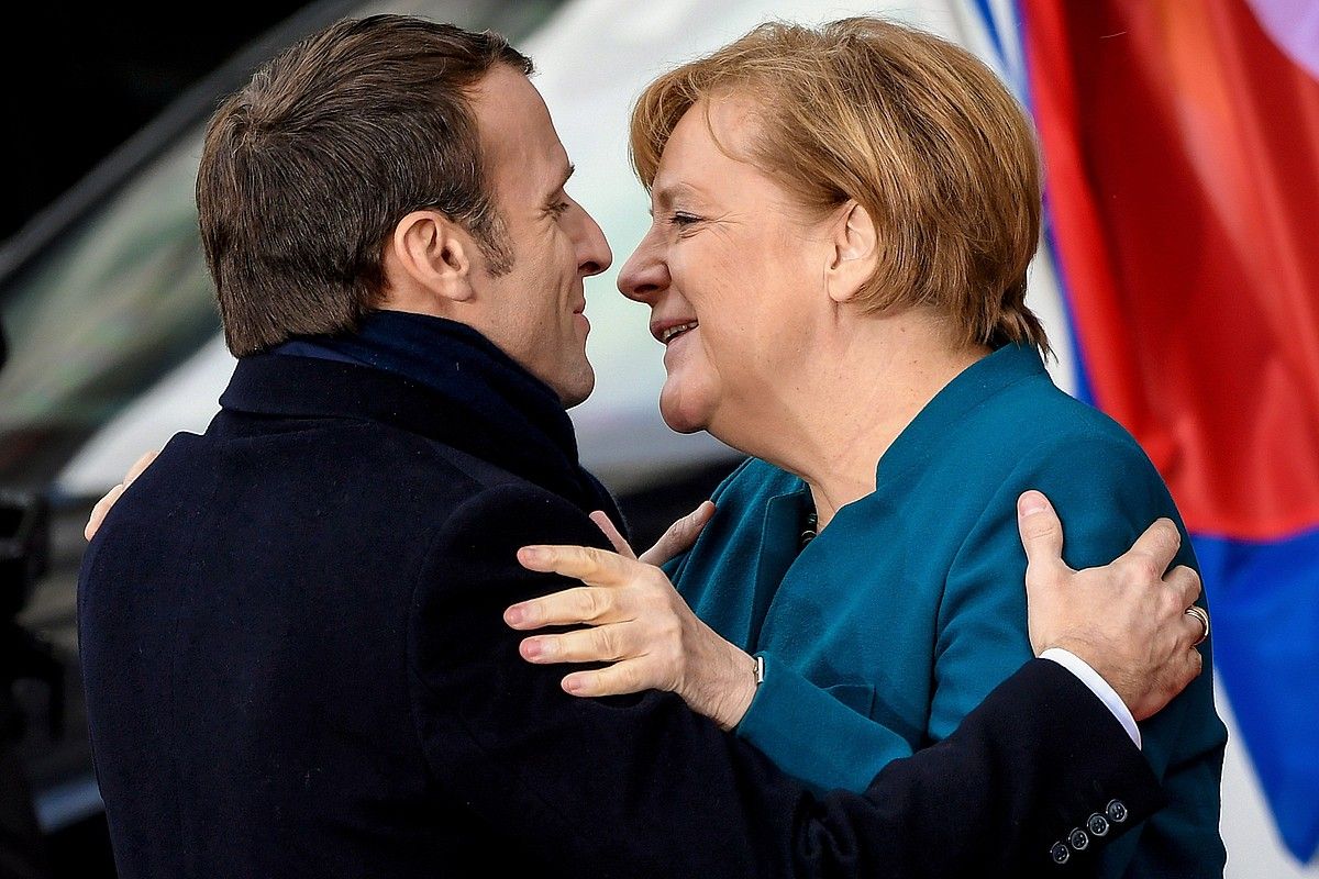 Macron Frantziako presidentea eta Merkel Alemaniako kantzilerra, elkar besarkatzen, atzo, Akisgrango Udaletxera sartu aurretik. SASCHA STEINBACH / EFE.