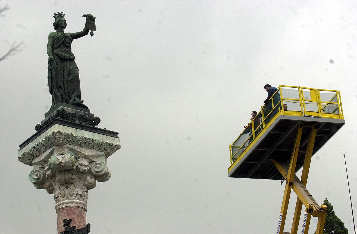 Herritar batzuk —alboko orrian— Nafarroako foruen estatua ikusten, igogailu batetik, 2003. urtean eginiko erakusketa baten harira. LANDER FERNANDEZ DE ARROIABE / FOKU.