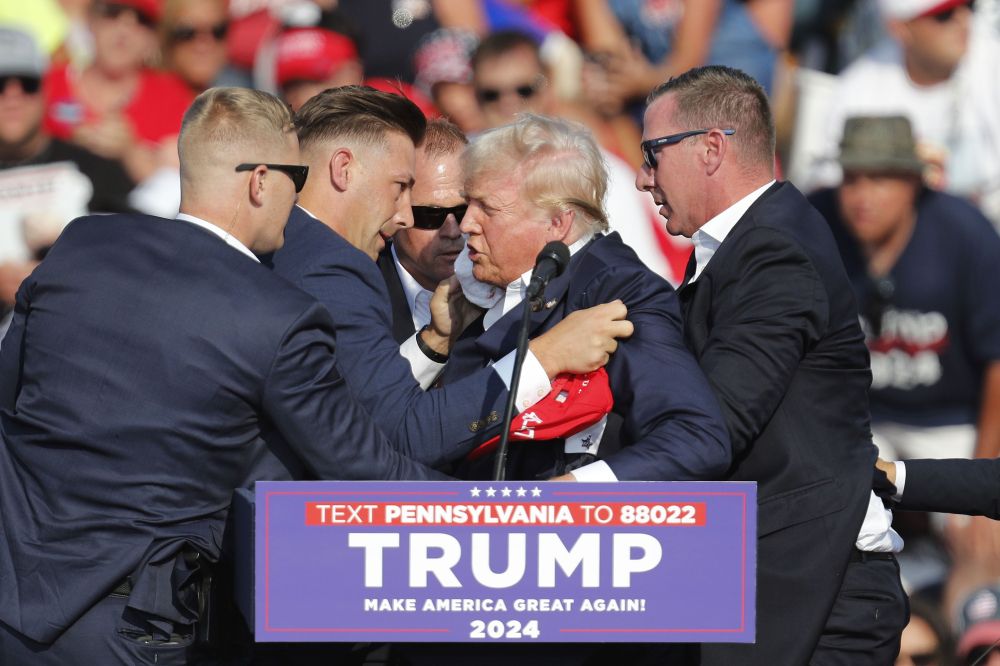 Trump, zerbitzu sekretukoek lagunduta, tiro hotsak entzun ondoren. DAVID MAXWELL / EFE Trump, zerbitzu sekretukoek lagunduta, tiro hotsak entzun ondoren. DAVID MAXWELL / EFE