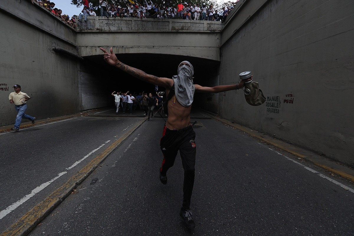 Juan Guaido oposizioko buruaren jarraitzaileak, atzo, Caracasen. Chavismoak ere protesta egin zuen hiriburuan. RAYNER PEÑA /EFE.