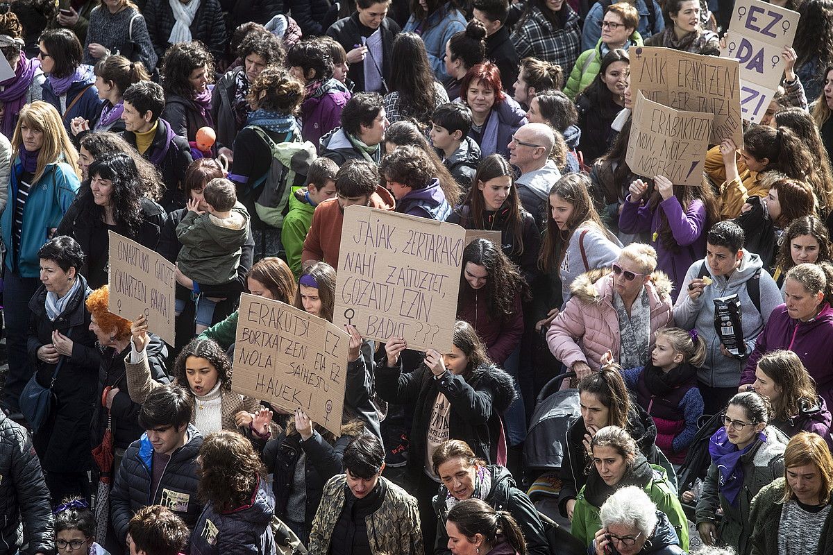 Ostiraleko greba feministaren irudi batean, emakume gazte batzuk indarkeriaren aurkako aldarrikapenekin, Donostian. JON URBE / FOKU.