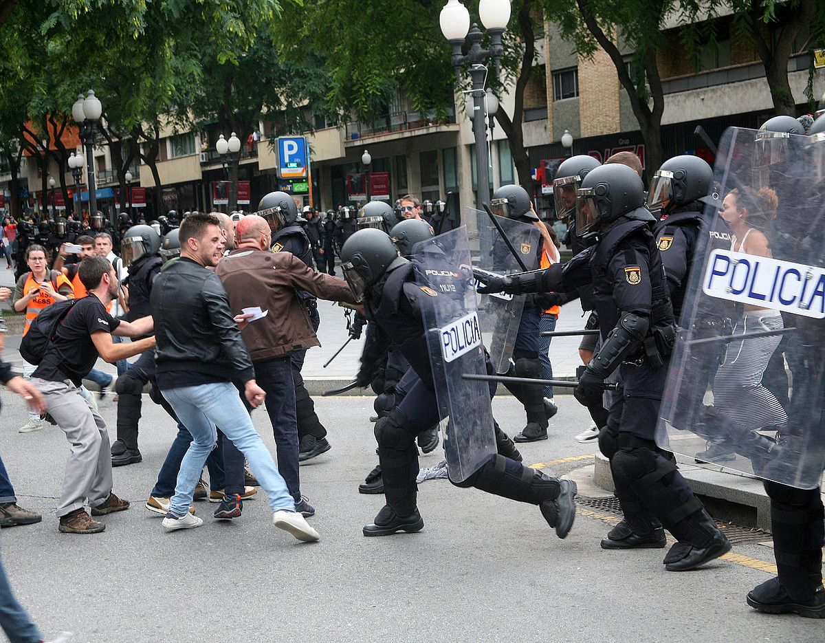 Espainiako Poliziaren agente batzuk herritar talde bati oldartzen, 2017ko urriaren 1ean, Tarragonan. JAUME SELLART / EFE.