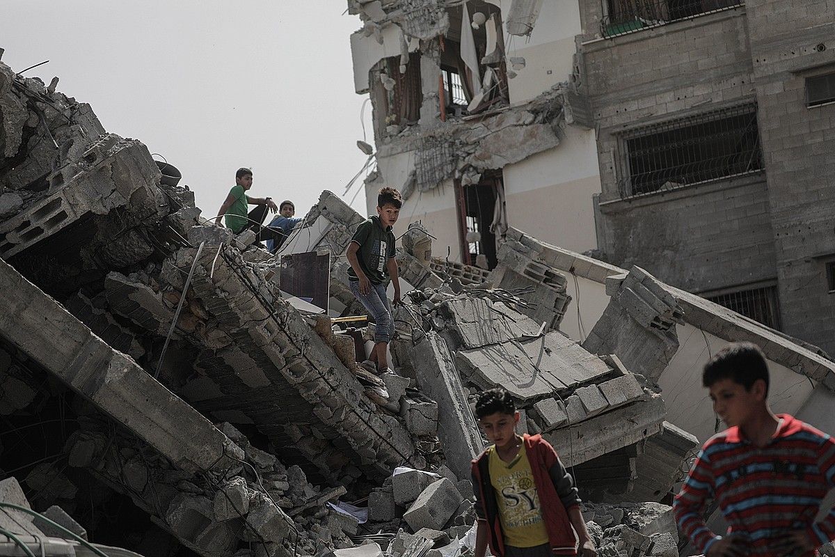 Haurrak jolasean, atzo, Israelgo armadak asteburuan egindako bonbardaketek suntsitutako eraikinen artean, Gazan. MOHAMMED SABER / EFE.