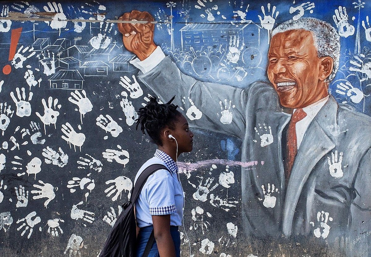 Ikasle bat atzo, Nelson Mandelaren mural baten aurretik pasatzen, Johannesburgon. KIM LUDBROOK / EFE. Ikasle bat atzo, Nelson Mandelaren mural baten aurretik pasatzen, Johannesburgon. KIM LUDBROOK / EFE.