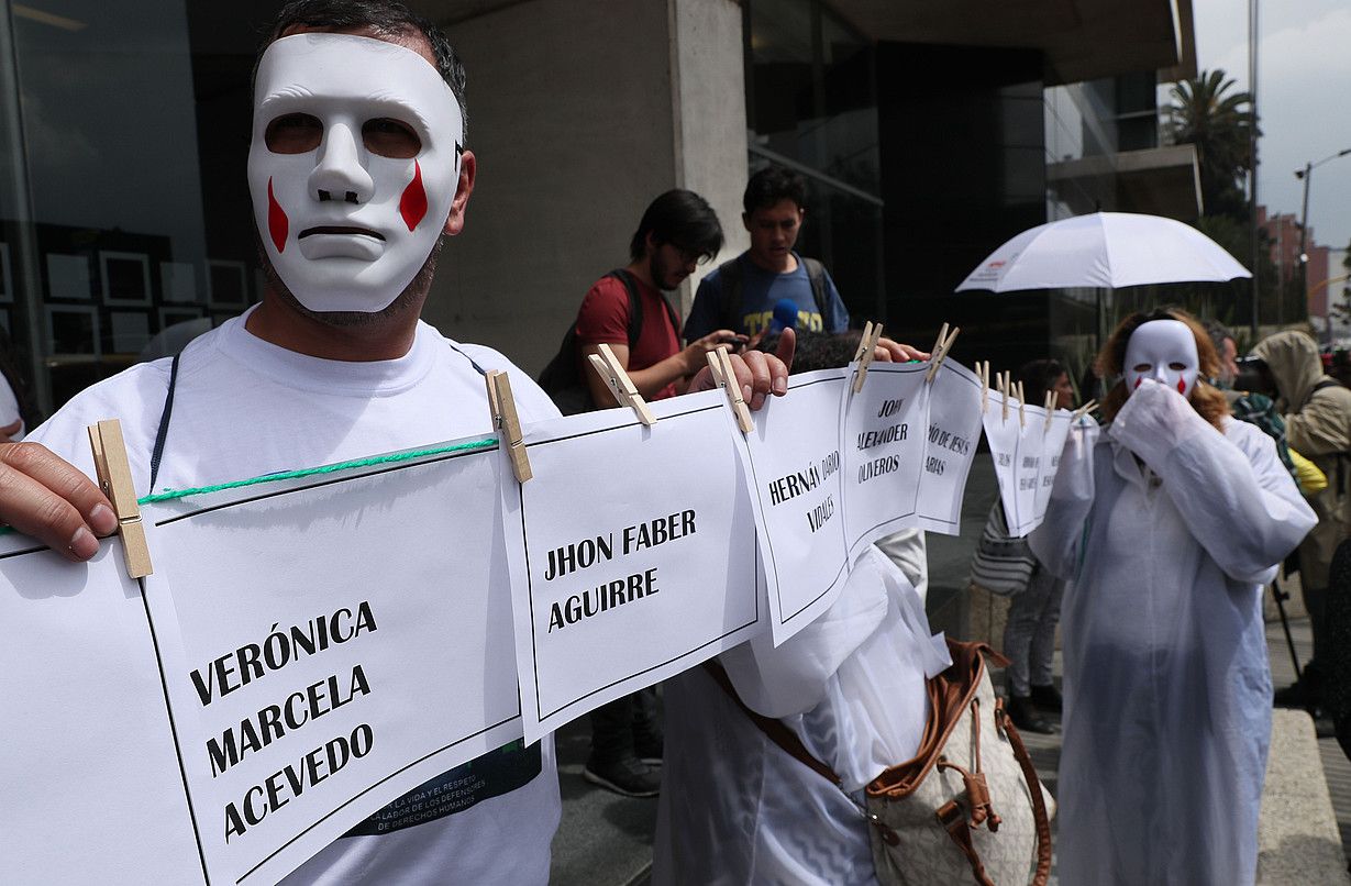 Hainbat pertsona protestan Bake Jurisdikzio Bereziaren egoitzaren aurrean, Bogotan, 2018an. Mario Montoya jeneral ohia deklaratzen ari zen. M. D. CASTAÑEDA / EFE.