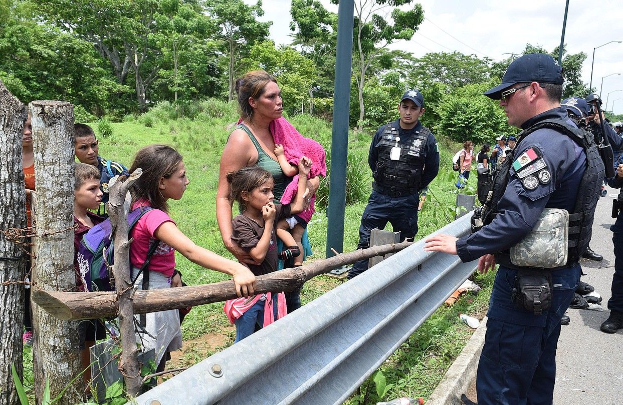Erdialdeko Amerikako etorkin familia bateko kideak Mexikoko poliziekin hizketan, joan den ostegunean, Tapachula inguruan (Mexiko). JOSE TORRES / EFE. Erdialdeko Amerikako etorkin familia bateko kideak Mexikoko poliziekin hizketan, joan den ostegunean, Tapachula inguruan (Mexiko). JOSE TORRES / EFE.