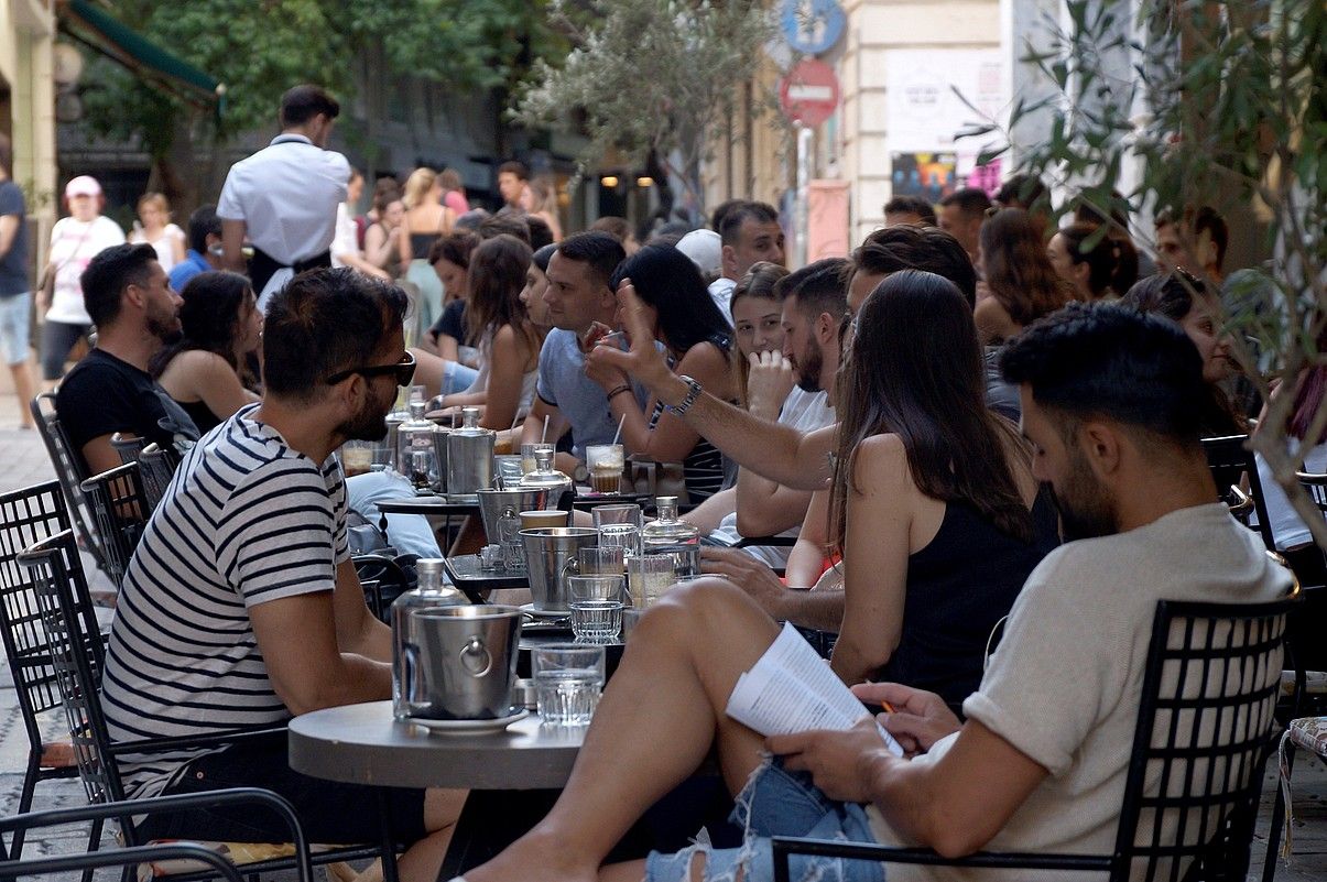 Gazte andana bat Atenas hiriburuaren erdiguneko terraza batzuetan. EMMA PONS VALLS / EFE.