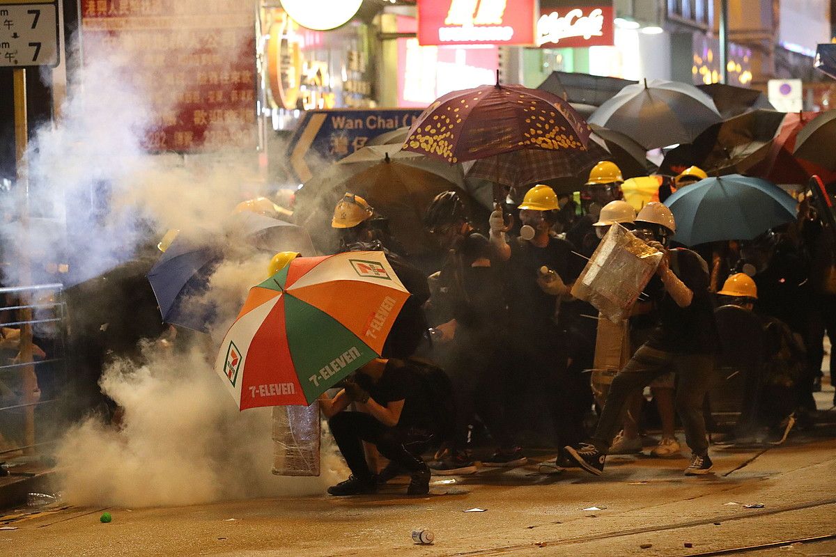 Manifestariak Poliziaren eraso batean defendatu nahian, herenegun Hong Kongen egindako protestan. RITCHIE B. TONGO / EFE. Manifestariak Poliziaren eraso batean defendatu nahian, herenegun Hong Kongen egindako protestan. RITCHIE B. TONGO / EFE.