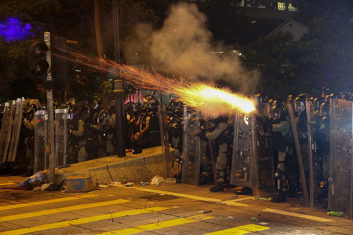 Hong Kongeko Poliziako kideak, atzo, mobilizazioa sakabanatzeko ahaleginean. Negar gasa jaurti zuten. JEROME FAVRE / EFE.