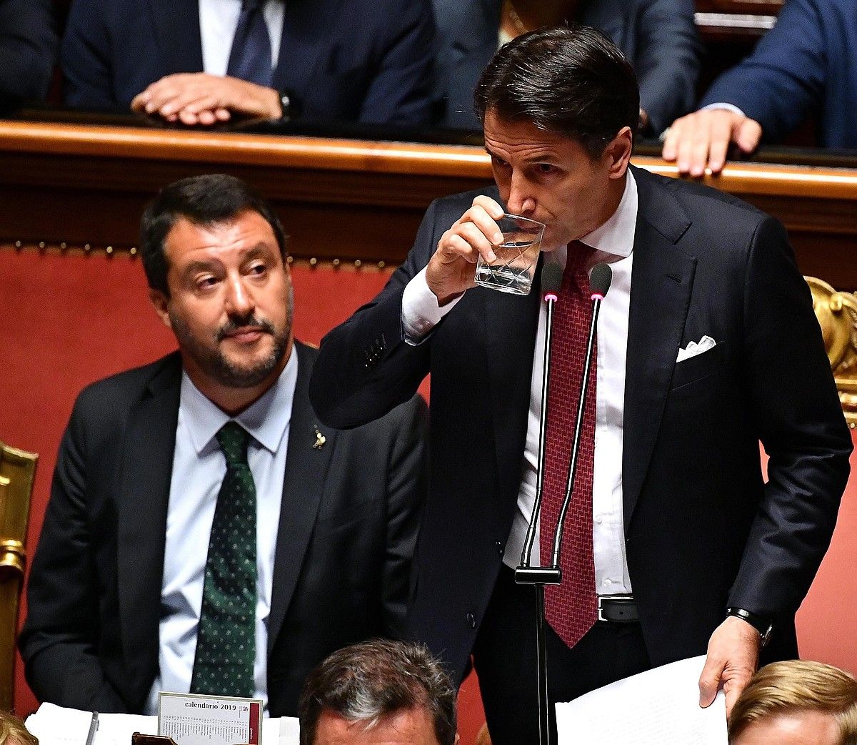 Conte ura edaten eta Salvini hari begira, Italiako Senatuko atzoko eztabaida saioan. ETTORE FERRARI / EFE.